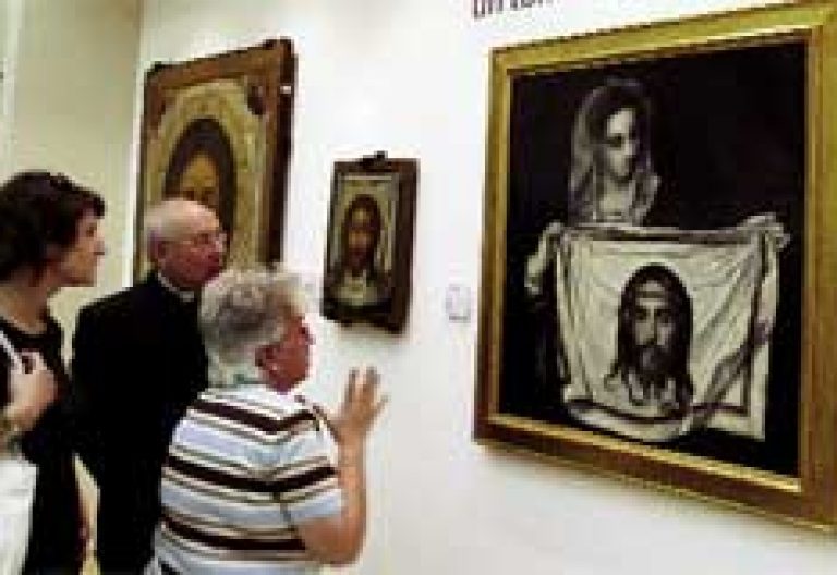 dos personas delante de un cuadro de temática religiosa