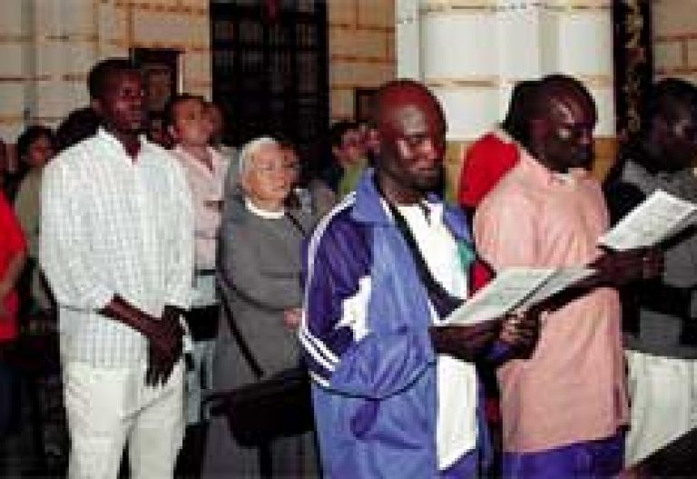 inmigrantes asisten a misa con españoles
