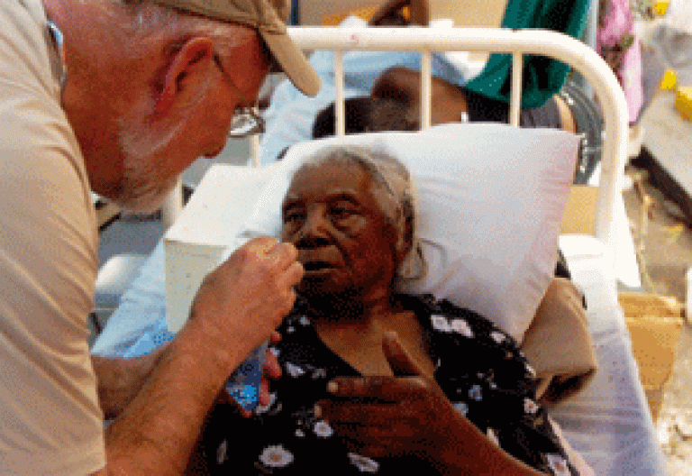 voluntario de Cáritas atiende a una anciana enferma