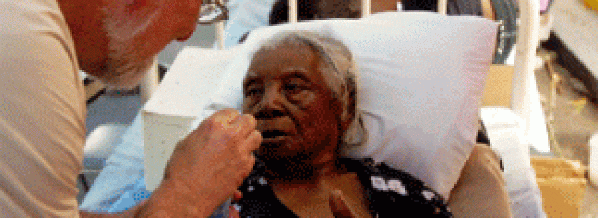 voluntario de Cáritas atiende a una anciana enferma