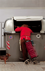 mujer rebusca contenedor de basura
