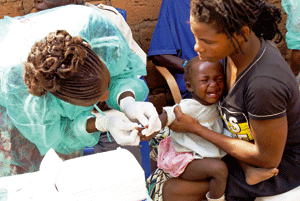 médico vacuna a una niña en Angola