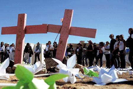 México gente rezando delante de cruces en tumbas