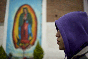 joven en México con una imagen de la Virgen de Guadalupe