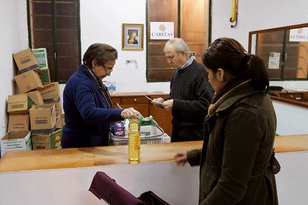 voluntarios de Cáritas reparten comida en un economato