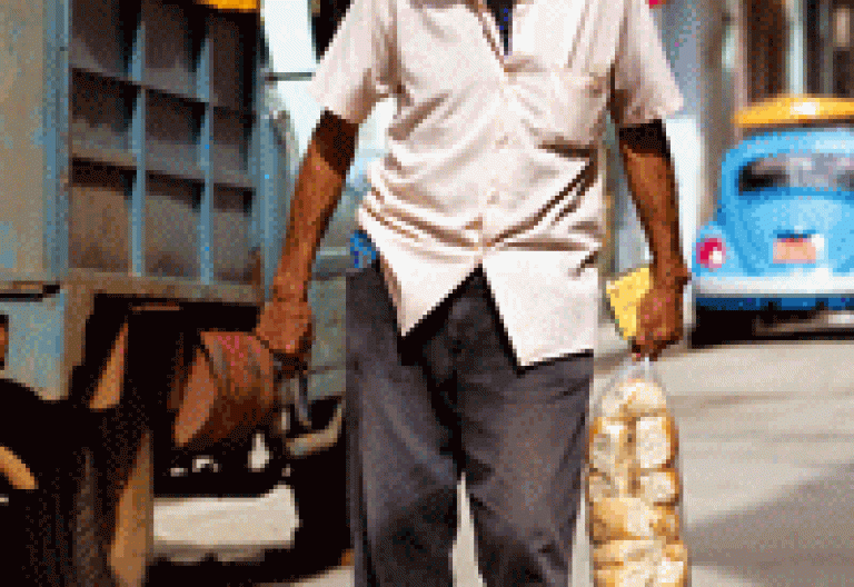un hombre en Cuba con una bolsa de pan