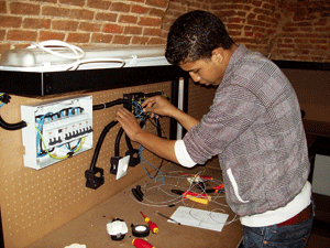 joven inmigrante trabaja en un taller gracias a Cáritas