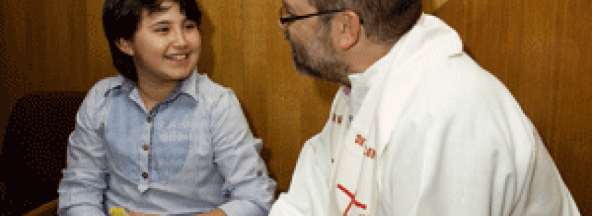niña con un sacerdote en catequesis para Primera Comunión