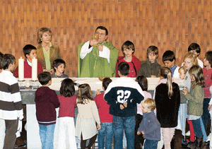 sacerdote con niños en altar catequesis