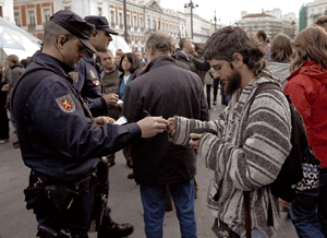 un joven indignado enseña su documentación a la policía en la Puerta del Sol