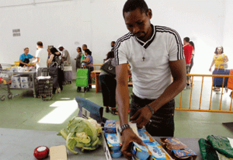 joven inmigrante en un reparto de alimento de Cáritas