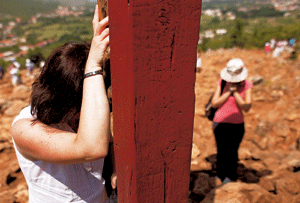 dos chicas cristianas en Bosnia rezando ante un crucifijo