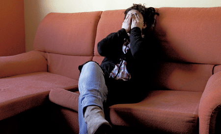 mujer llora en el sofá porque van a desahuciarla de su casa