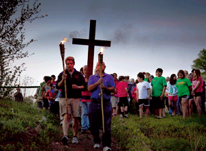 procesión de unos niños y jóvenes con cruz en el campo