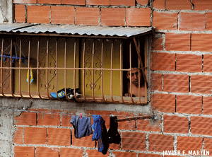 un hombre en la ventana en una casa de ladrillos en Venezuela