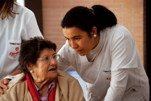 voluntaria de Cáritas con una anciana