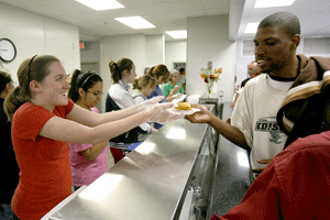 voluntaria católica en un comedor con un inmigrante