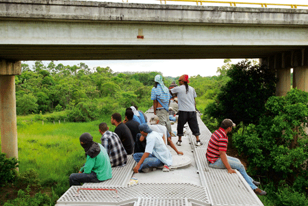 migrantes en México encima de un tren intentando escapar a los Estados Unidos