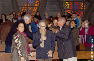 grupo de gente en el momento de la paz durante la celebración de la misa