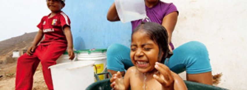 mujer madre bañando a niños en Perú