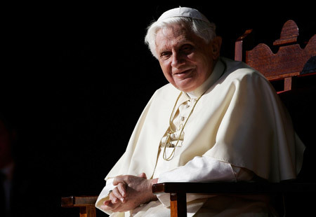 papa Benedicto XVI posa sentado sobre fondo negro