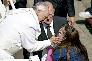 papa Francisco acaricia a una niña