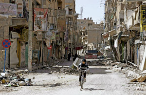 niño en bicicleta en Siria calles destrozadas por la guerra