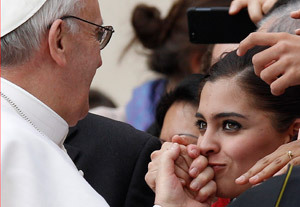 una mujer besa la mano del papa Francisco