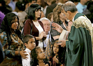 mujeres con niños en la iglesia ante un sacerdote