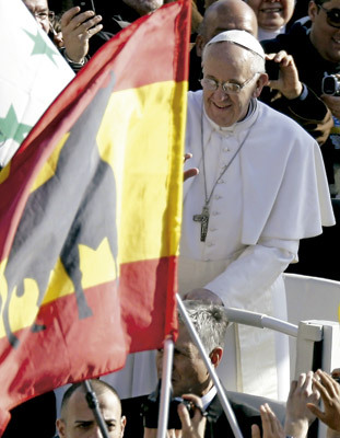 papa Francisco pasa al lado de una bandera de España