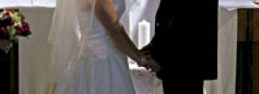 un sacerdote oficia la boda católica mientras los novios están cogidos de la mano