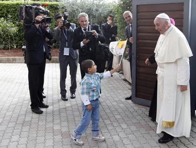 El Papa se encuentra con un niño en la residencia de Cáritas en Asís (EFE)