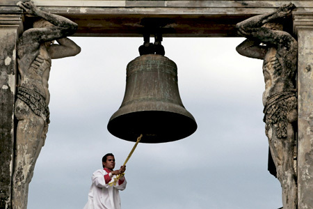 monaguillo toca campana en el campanario de una iglesia