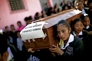 varias chicas jóvenes portan un ataúd en Guatemala