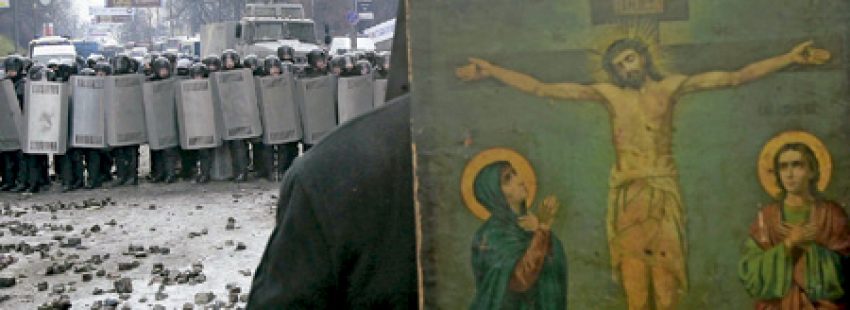 sacerdote cristiano mediando entre la policía y los manifestantes en Ucrania