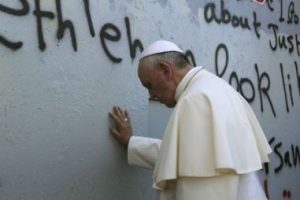 El papa Francisco toca el muro que divide Israel de Cisjordania.
