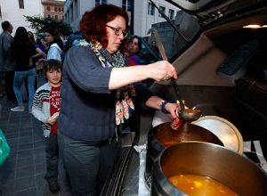 Una mujer se sirve sopa en un reparto de alimento para los necesitados, en Valencia.