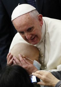 Pope Francis embraces sick child during audience with accountants at Vatican