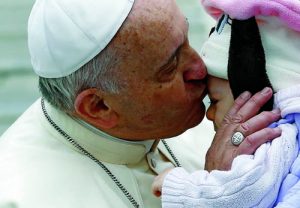 Pope Francis kisses baby as he leaves general audience in St. Peter's Square at Vatican