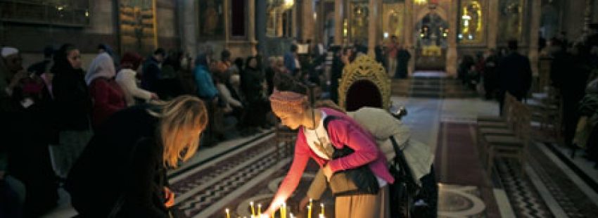 cristianos encienden velas y rezan en el Santo Sepulcro de Jerusalén