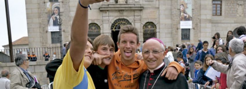 dos jóvenes se hacen un selfie con el obispo de Ávila, Jesús García Burillo