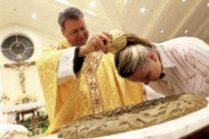 sacerdote bautizando a una chica en una capilla