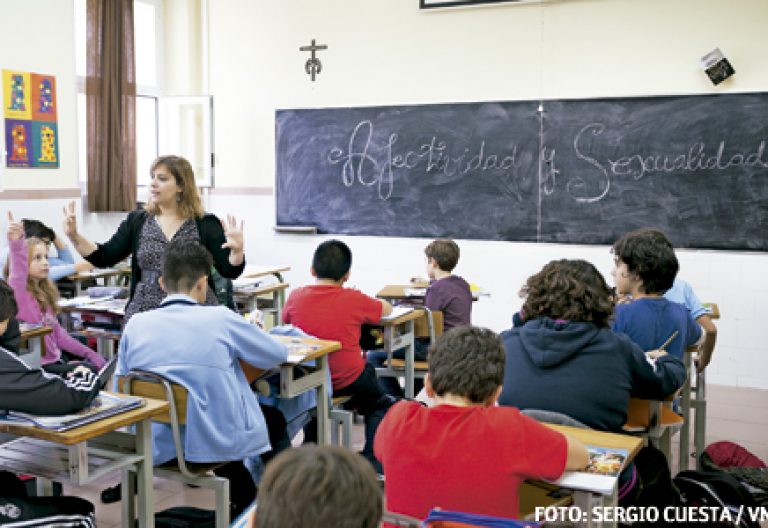 alumnos en la escuela católica con profesora que está explicando educación sexual con valores cristianos