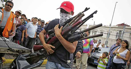chico armado con varias escopetas y fusiles