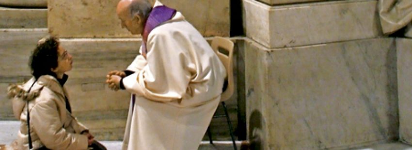 sacerdote sentado en un banco confesando a una mujer de rodillas en el suelo en el Vaticano