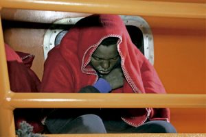 inmigrante llegado en patera a las costas de Europa recogido del mar y tapado con una manta