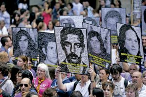 marcha ciudadana en Argentina con carteles con fotos de personas desaparecidas durante la dictadura