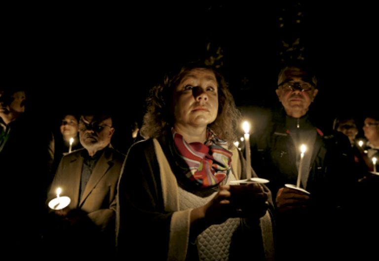fieles católicos de Malta en una celebración con velas
