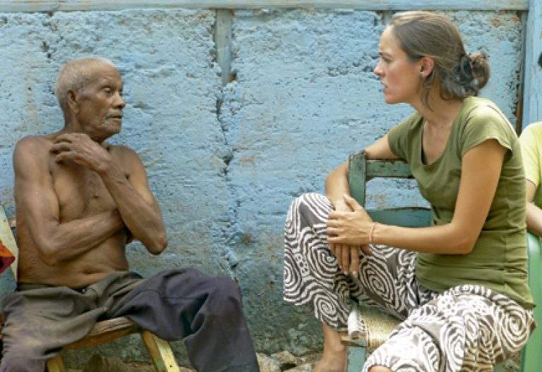 chica joven misionera laica en República Dominicana hablando con un hombre mayor