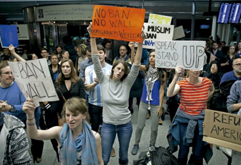 protesta de un grupo de manifestantes en un aeropuerto contra el muro de Trump